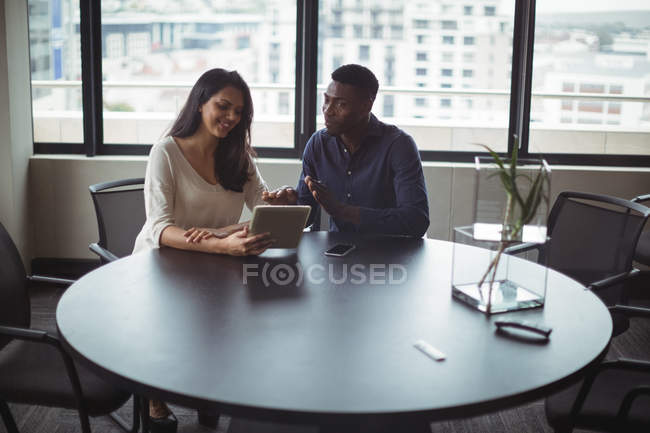 Бізнесмен і колега обговорюють цифровий планшет в офісі — стокове фото