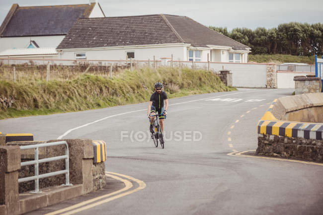 Athlete riding sport bicycle on country road — Stock Photo