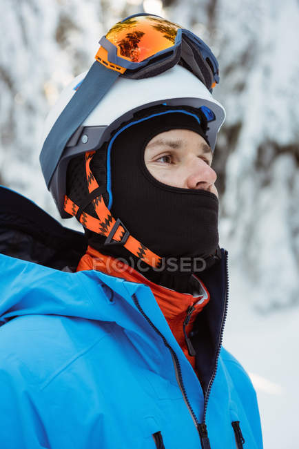 Skifahrer steht und schaut weg auf verschneite Landschaft — Stockfoto