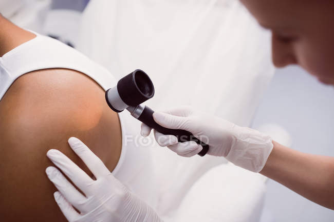Doctor removing mole with laser treatment in clinic — Stock Photo