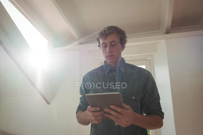 Чоловік стоїть в кімнаті тримає цифровий планшет — стокове фото