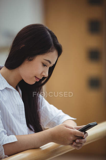 Close-up of businesswoman using mobile phone at office balcony — Stock Photo