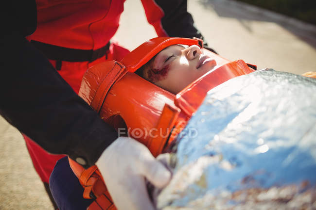 Mujer lesionada tratada por paramédico en el lugar del accidente - foto de stock
