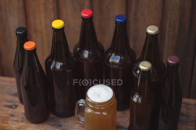 Bottiglie di birra fatte in casa e una tazza di birra in una birreria casalinga — Foto stock