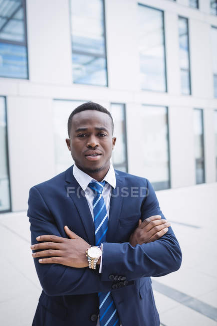 Портрет бізнесмена зі зброєю, що стоїть за межами офісної будівлі — стокове фото