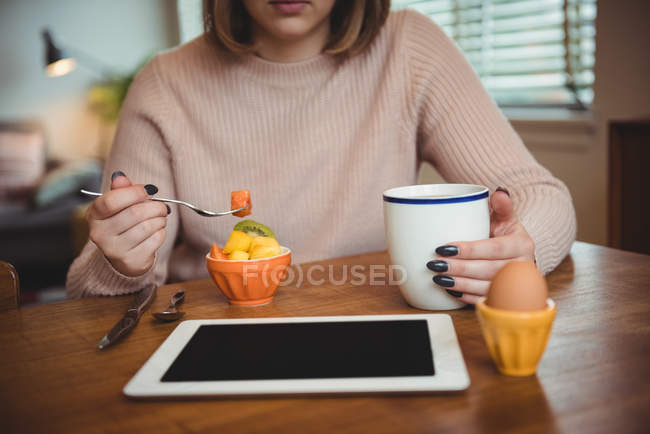 Жінка снідає у вітальні вдома — стокове фото