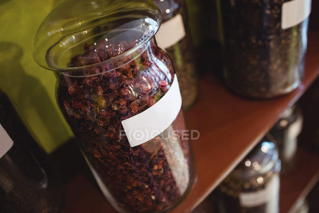 Close-up de frascos de especiarias dispostos em prateleiras na loja — Fotografia de Stock