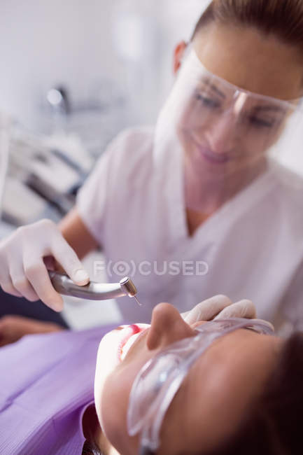Dentista esaminando paziente femminile in clinica — Foto stock