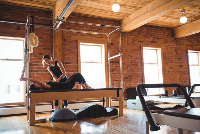 Trainerin hilft Frau beim Pilates-Training im Fitnessstudio — Stockfoto