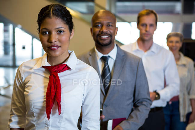 Портрет женского персонала и пассажиров, стоящих в терминале аэропорта — стоковое фото