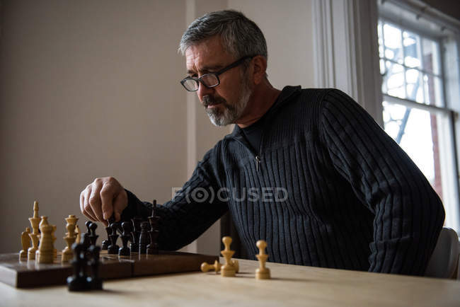 Attentive man playing chess at home — Stock Photo