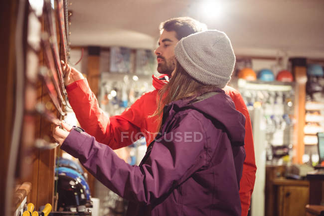 Пара вибирає лижний полюс разом у магазині — стокове фото