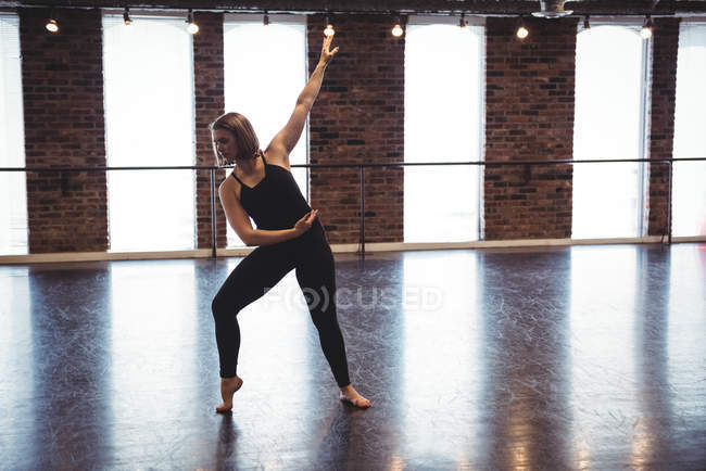 Young woman practicing modern dance in dance studio — Stock Photo