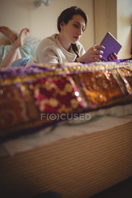 Mulher bonita usando tablet digital na cama em casa — Fotografia de Stock
