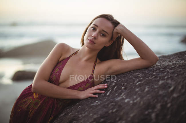 Ritratto di bella donna appoggiata sulla roccia in spiaggia — Foto stock
