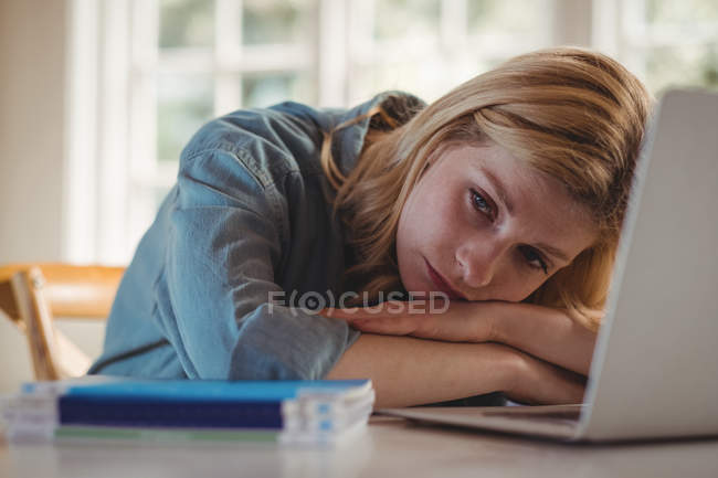Женщина расслабляется за столом, используя ноутбук в гостиной дома — стоковое фото