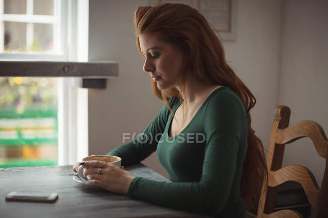 Mulher ruiva tomando café no restaurante — Fotografia de Stock
