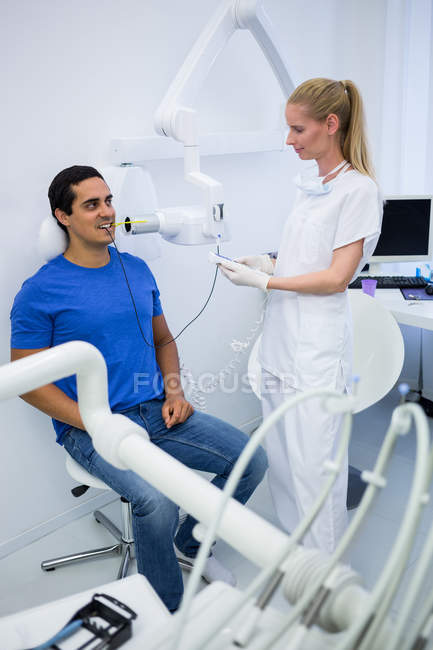 Dentista femminile che fa una radiografia dei denti del paziente in clinica — Foto stock
