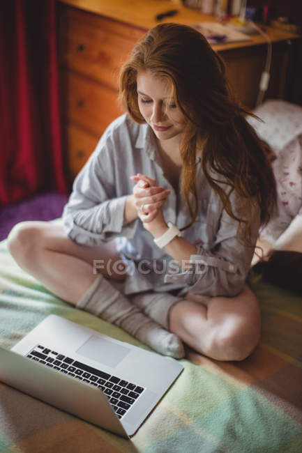 Mulher com as mãos apertadas sentado na frente do laptop em casa — Fotografia de Stock
