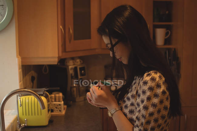 Жінка має каву на кухні вдома — стокове фото