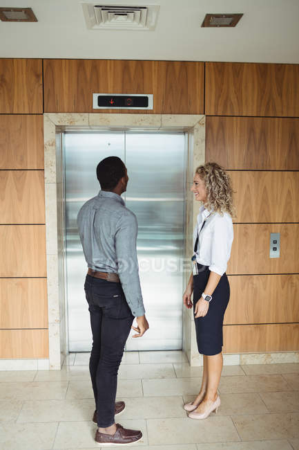 Executivos de negócios à espera de elevador no escritório — Fotografia de Stock