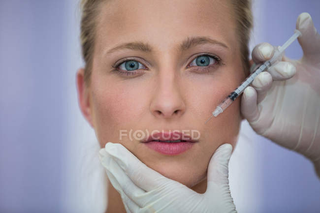 Primo piano della paziente adulta di mezza età che riceve un'iniezione di botox sul viso — Foto stock