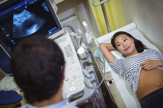 Médico haciendo ultrasonido para paciente en el hospital - foto de stock