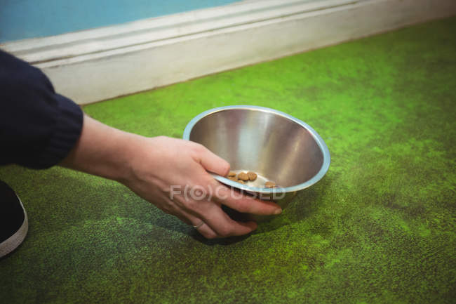 Close-up of woman holding dog bowl at dog care center — Stock Photo