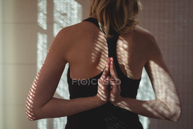Vista posteriore della donna che pratica yoga a casa — Foto stock