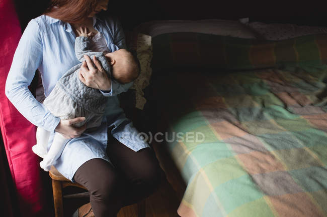 Mutter stillt Neugeborenes zu Hause im Schlafzimmer — Stockfoto
