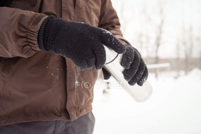 Mittelteil der Musher hält Thermoskanne im Winter — Stockfoto