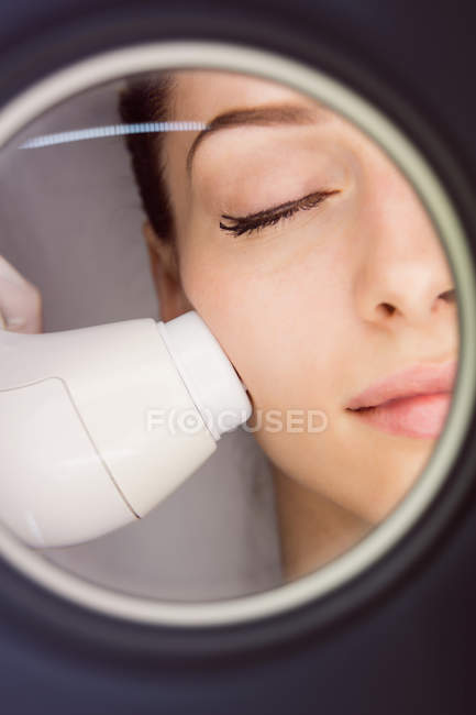Doctor giving facial massage to patient through sonic lifting in clinic — Stock Photo