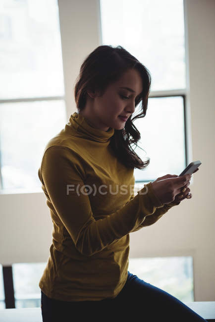 Woman using mobile phone at home — Stock Photo