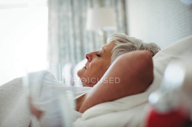 Senior woman sleeping on bed in bedroom at home — Stock Photo