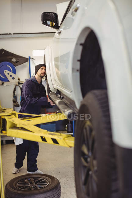Mechanic examining a car in repair garage — Stock Photo