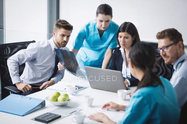 Equipe de médico discutindo sobre laptop em reunião na sala de conferência — Fotografia de Stock