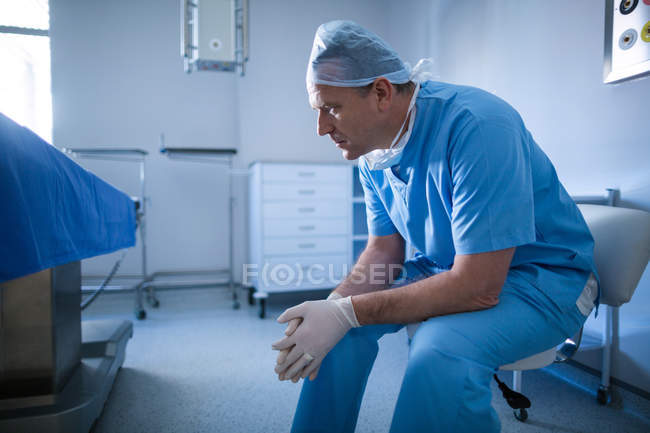 Чоловічий хірург сидить на стільці в лікарні — стокове фото