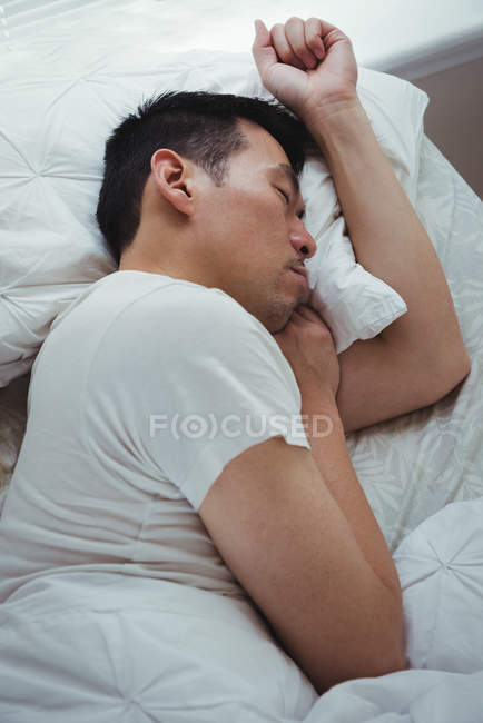 Hombre durmiendo en el dormitorio en casa - foto de stock