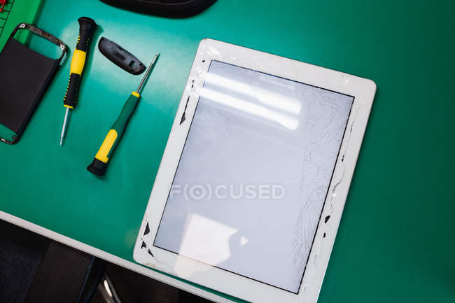 Primer plano de la tableta digital dañada en el centro de servicio - foto de stock
