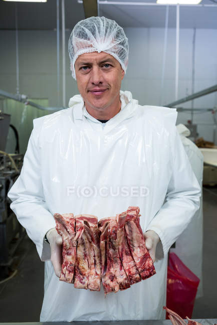 Портрет м'ясника, що тримає м'ясо на м'ясному заводі — стокове фото