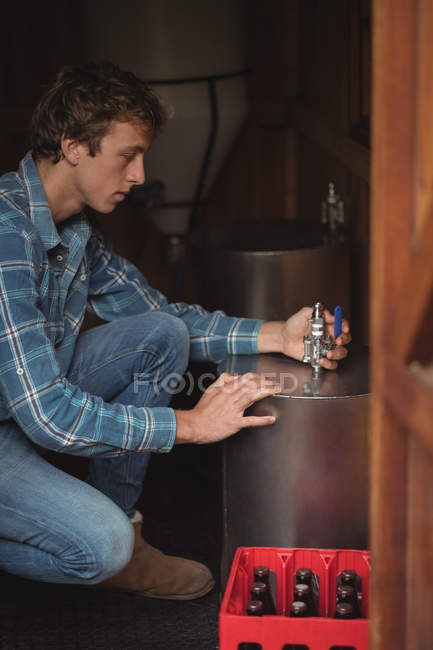 Close-up of man fixing valve to beer wort to make beer at home brewery — Stock Photo