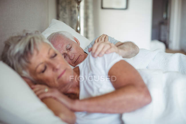 Couple sénior dormant sur le lit dans la chambre — Photo de stock