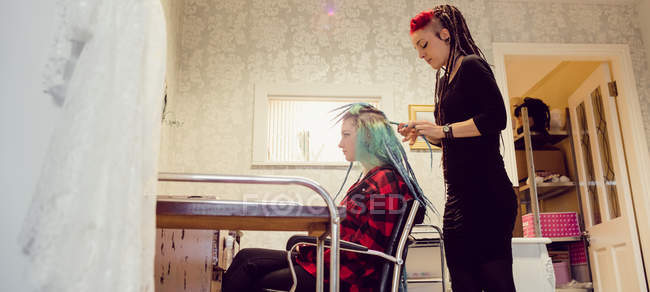 Esthéticienne coiffeur clients cheveux dans dreadlocks boutique — Photo de stock