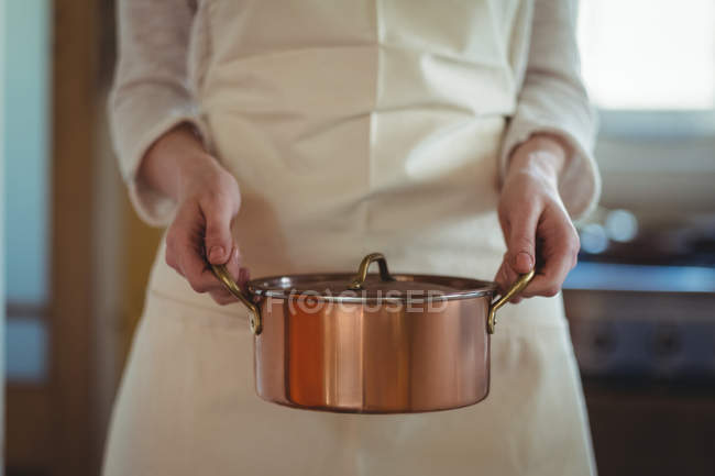 Розділ середині Жінка тримає каструлю кухні в домашніх умовах — стокове фото