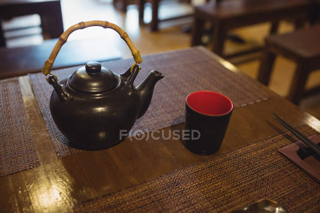 Teapot and mug on dining table in restaurant — Stock Photo