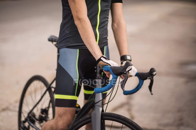 Meados de seção do atleta de pé com bicicleta — Fotografia de Stock
