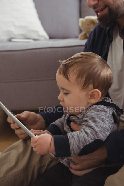 Отец и ребенок с помощью цифрового планшета в гостиной дома — стоковое фото