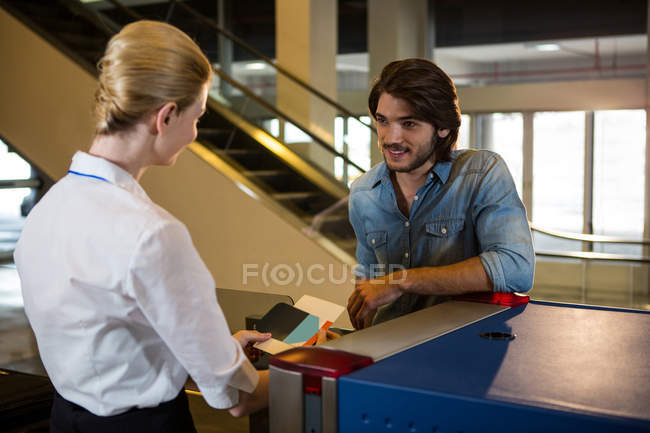 Пасажир веде розмову з жіночим персоналом в терміналі аеропорту — стокове фото