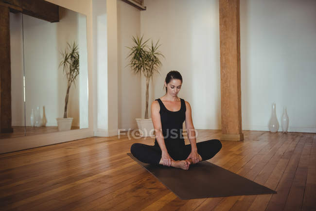 Mulher praticando ioga no estúdio de fitness — Fotografia de Stock