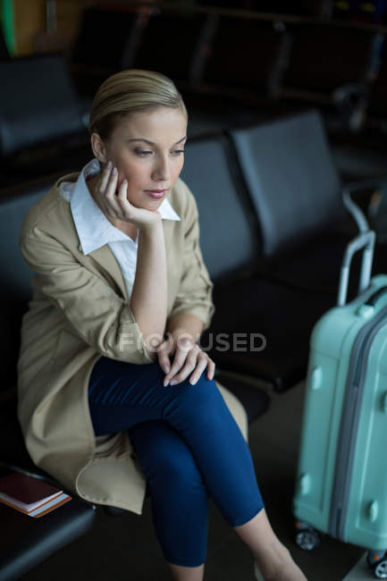 Nachdenkliche Pendlerin wartet im Wartebereich am Flughafen — Stockfoto